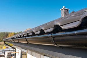 a-metal-black-gutter-on-a-roof-covered-with-ceramic-tiles-close-up-shot-roof-gutter-gutter-roofing_t20_6m0E4O