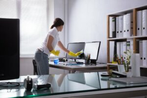 Woman Cleaning Computer In Office